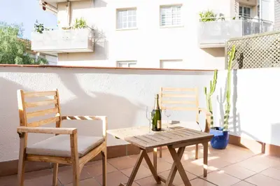 a table and two chairs and a bottle of wine on a balcony at Central - a 10 minutos de la paya in Sitges