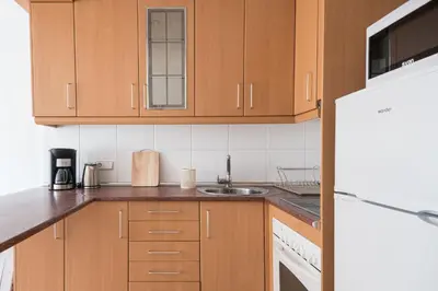 a kitchen with wooden cabinets and a sink at Cozy Apt with charm and exquisite natural light in Barcelona