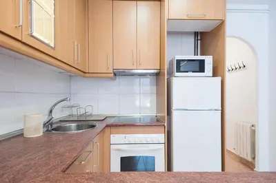 a kitchen with a white refrigerator and a sink at Cozy Apt with charm and exquisite natural light in Barcelona