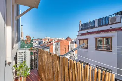 a view of a city from a balcony with a wooden fence at Cozy Apt with charm and exquisite natural light in Barcelona