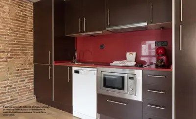 a kitchen with brown cabinets and a microwave at Barnapartments Raval in Barcelona