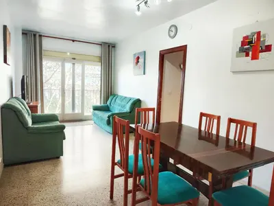 a dining room with a wooden table and chairs at Apartamento Diagonal Mar, cerca del Forum y Playa in Barcelona