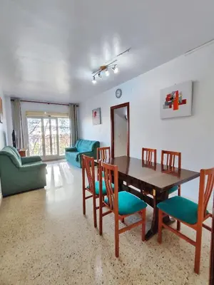 a living room with a wooden table and chairs at Apartamento Diagonal Mar, cerca del Forum y Playa in Barcelona