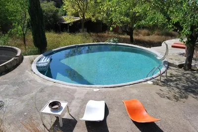 a small swimming pool with chairs and a table at Masia Vilatersana in Sant Llorenc Savall