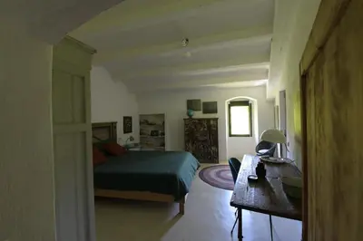 a bedroom with a bed and a desk in a room at Masia Vilatersana in Sant Llorenc Savall