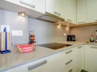 a kitchen with white cabinets and a counter top at Ocean Skyline Penthouse by Hello Homes Sitges in Sitges