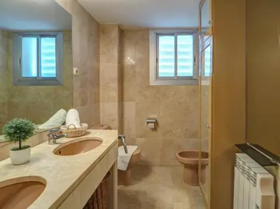 a bathroom with two sinks and a toilet and a shower at Ocean Skyline Penthouse by Hello Homes Sitges in Sitges
