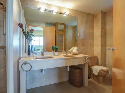a bathroom with a sink and a mirror and a toilet at Ocean Skyline Penthouse by Hello Homes Sitges in Sitges