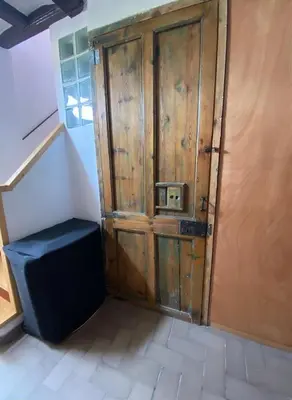 a wooden door with a stool in a room at CAM Maresme 1 apartamento Barcelona y playa in Masnou