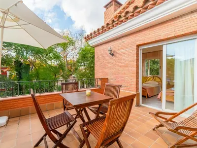 a patio with a wooden table and chairs and an umbrella at Holiday Home Aurea by Interhome in Pineda de Mar