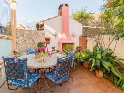 a patio with a table and chairs and a fireplace at Holiday Home Aurea by Interhome in Pineda de Mar
