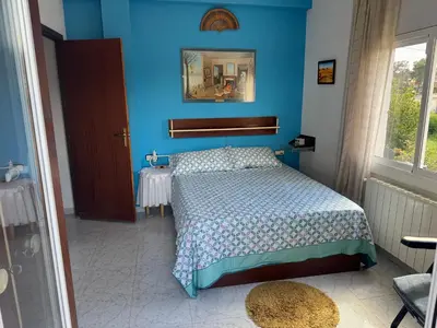 a blue bedroom with a bed and a mirror at Villa Maria Mercedes in Olesa de Bonesvalls