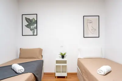 two beds in a room with two pictures on the wall at The Collection Barcelona - Plaza Urquinaona Central and comfortable 3BD in Barcelona