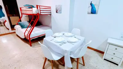 a dining room with a table and a bunk bed at Hostal Estudios in Badalona