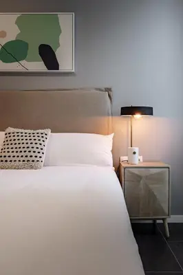 a bedroom with a white bed and a night stand at CATERINA 22@ POBLENOU in Barcelona