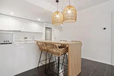 a kitchen with a counter with stools and two lights at CATERINA 22@ POBLENOU in Barcelona