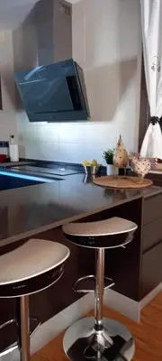 a kitchen with two bar stools in front of a counter at Villa Alba cerca de Sitges in Canyelles