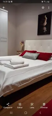 a bed with white sheets and red pillows on it at Villa Alba cerca de Sitges in Canyelles