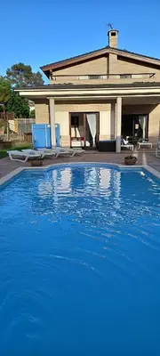 a large blue swimming pool in front of a house at Villa Alba cerca de Sitges in Canyelles