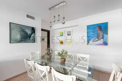 a dining room with a glass table and white chairs at Sitges PORT - Con piscina, a 5 minutos de la playa in Sitges