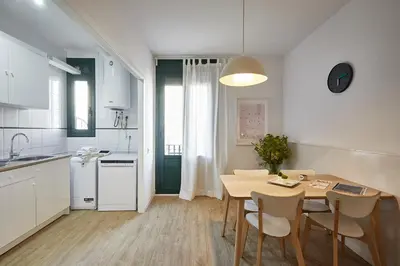 a kitchen and dining room with a table and chairs at BBarcelona Clot Apartments in Barcelona