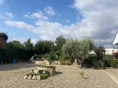 a garden with rocks and a bench in a yard at Villa Òdena in Odena