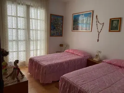two beds in a bedroom with pink sheets and windows at Villa Òdena in Odena