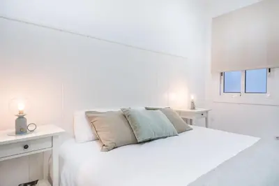a white bedroom with a white bed and a window at Apartment Next to Sagrada Familia, the Essence of Barcelona in Barcelona