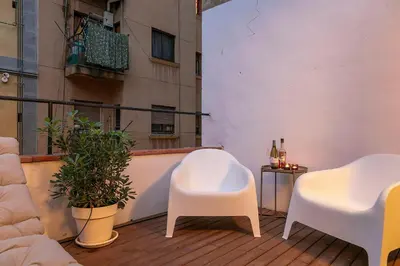 a balcony with two white chairs and a table at Penthouse with Rooftop apartment in the Barceloneta - Barcelona in Barcelona