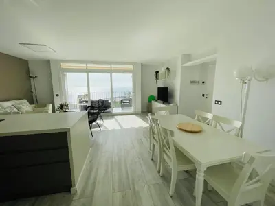 a kitchen and living room with a table and chairs at La Marina2 SeaView with amazing terrace in Sitges