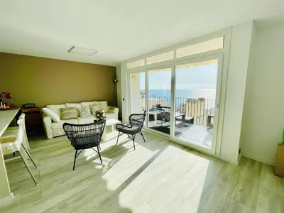 a living room with a couch and a table and chairs at La Marina2 SeaView with amazing terrace in Sitges