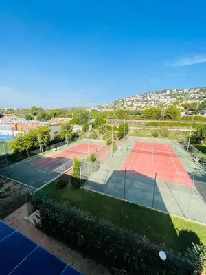 a tennis court with two tennis courts at La Marina2 SeaView with amazing terrace in Sitges