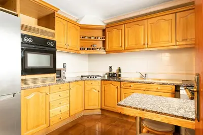 a kitchen with wooden cabinets and a counter top at Barcelona Beach Home in Barcelona