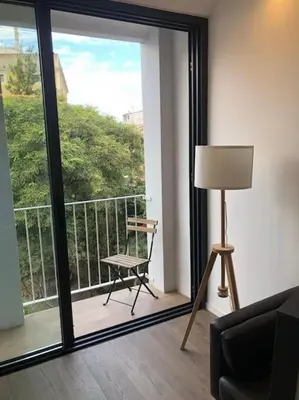 a room with a balcony with a chair and a window at L'Havana Xica in Vilanova i la Geltrú
