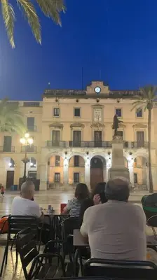 a group of people sitting in chairs in front of a building at L'Havana Xica in Vilanova i la Geltrú