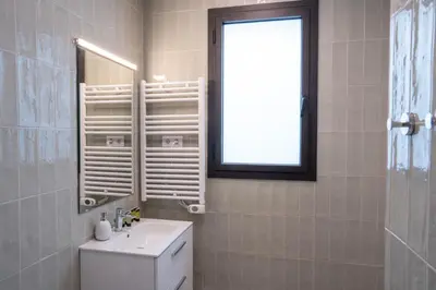 a bathroom with a toilet and a sink and a window at Feelathome Stadium Apartments in Hospitalet de Llobregat