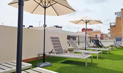 a row of chairs and umbrellas on a roof at Feelathome Stadium Apartments in Hospitalet de Llobregat
