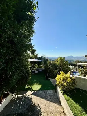 a garden with a table and an umbrella at Spirit of Queen experience in Barcelona