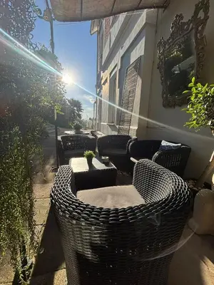 a patio with wicker chairs and tables on a house at Spirit of Queen experience in Barcelona
