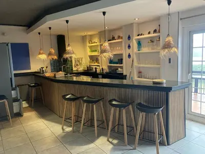 a bar with black stools and blue plates on a counter at El Cedre Blau Vivienda con piscina en Granollers in Granollers