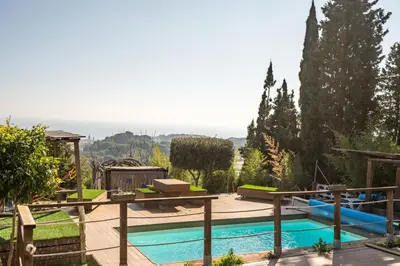 a swimming pool with a wooden deck at \u30c4 Villa Carrasca l Luxe l Vista al Mar l Piscina Climatizada l Nature in Arenys de Munt