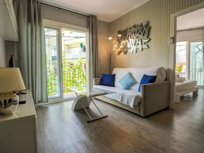a living room with a couch and a table at Pura Vida Apartment by Hello Homes Sitges in Sitges