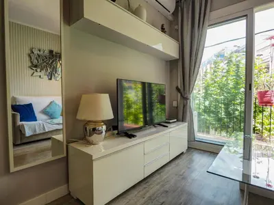 a living room with a television and a window at Pura Vida Apartment by Hello Homes Sitges in Sitges