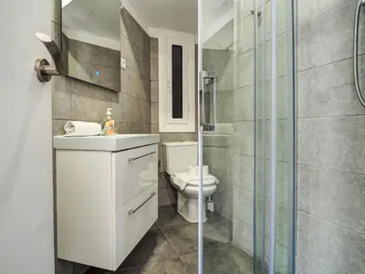 a bathroom with a toilet and a glass shower at Pura Vida Apartment by Hello Homes Sitges in Sitges