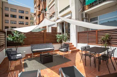 a patio with tables and chairs and a white canopy at Tendency Apartments Miro 8 in Barcelona