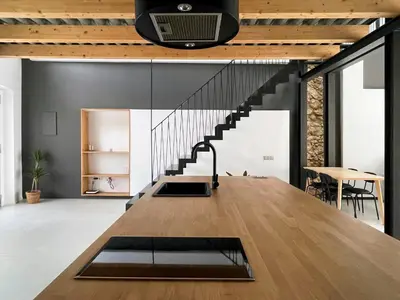 a living room with a large wooden table and a staircase at villa en el penedès in Gornal