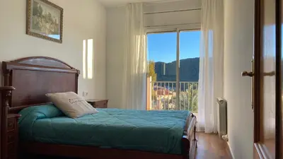 a bedroom with a bed and a large window at RACÓ DEL GARRAF Ca la Matilde house BBQ and POOL in Olivella