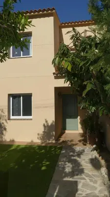 a house with a green door in a yard at RACÓ DEL GARRAF Ca la Matilde house BBQ and POOL in Olivella