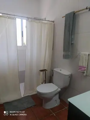 a bathroom with a toilet and a shower curtain at Habitación privada en casa particular, montaña in Olesa de Bonesvalls