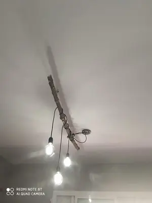 a ceiling light with three lights on a ceiling at Habitación privada en casa particular, montaña in Olesa de Bonesvalls